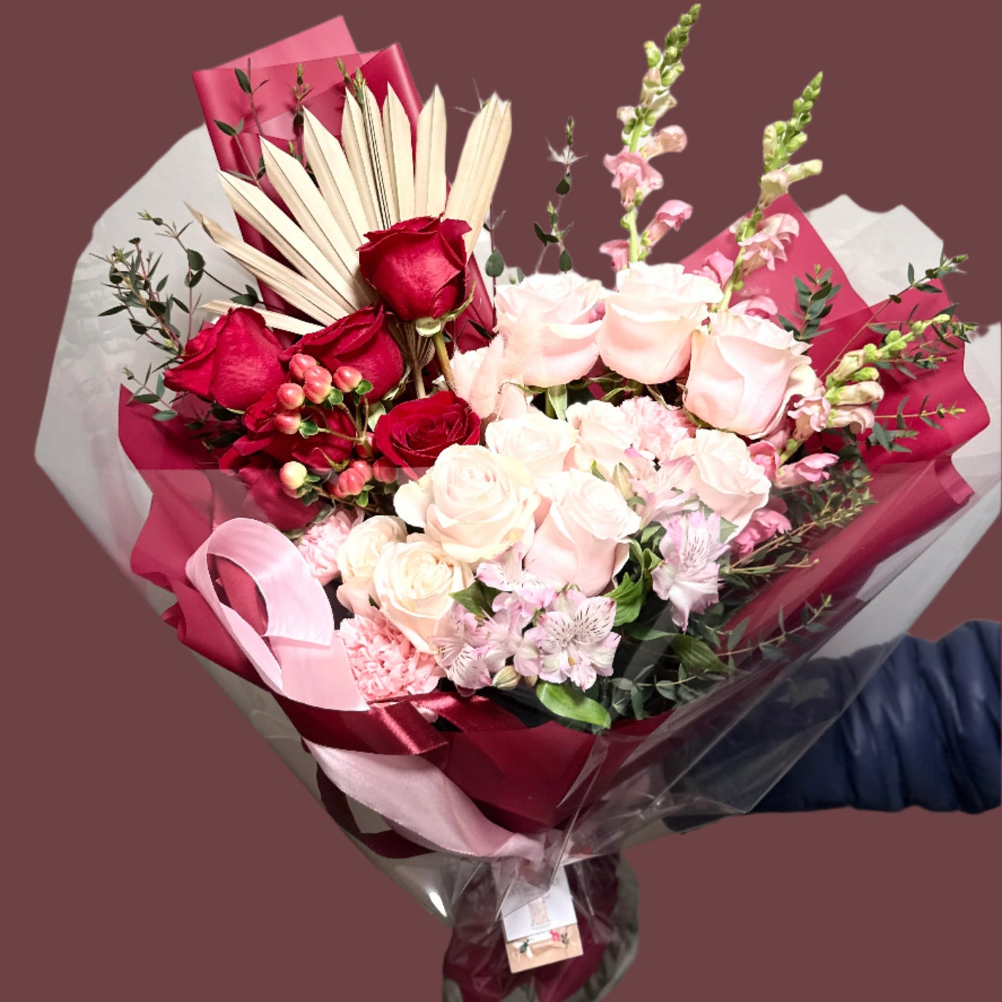 Luxury flower bouquet of premium pink, red roses in red wrapping paper.
