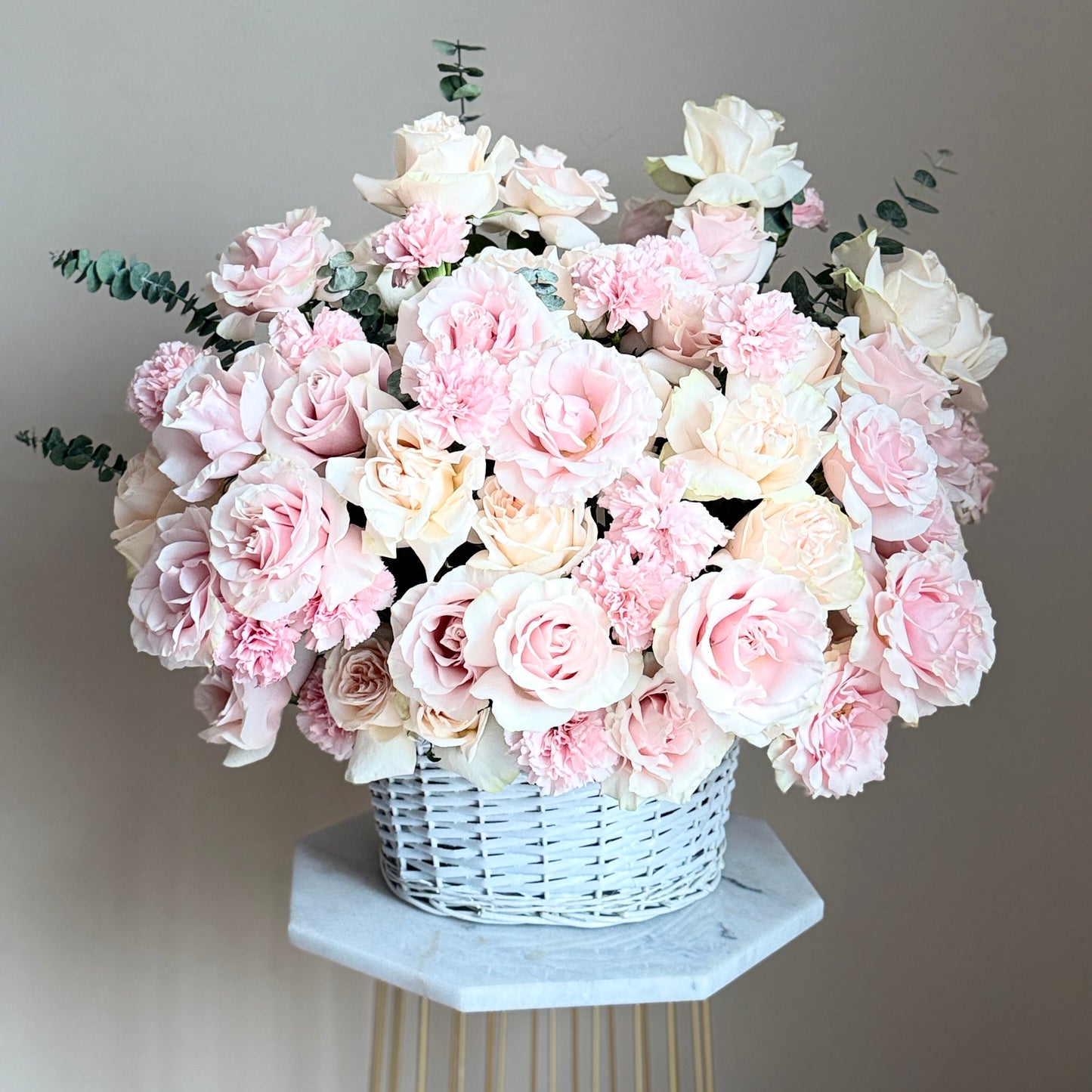Bouquet of pink and white flowers in a white large basket