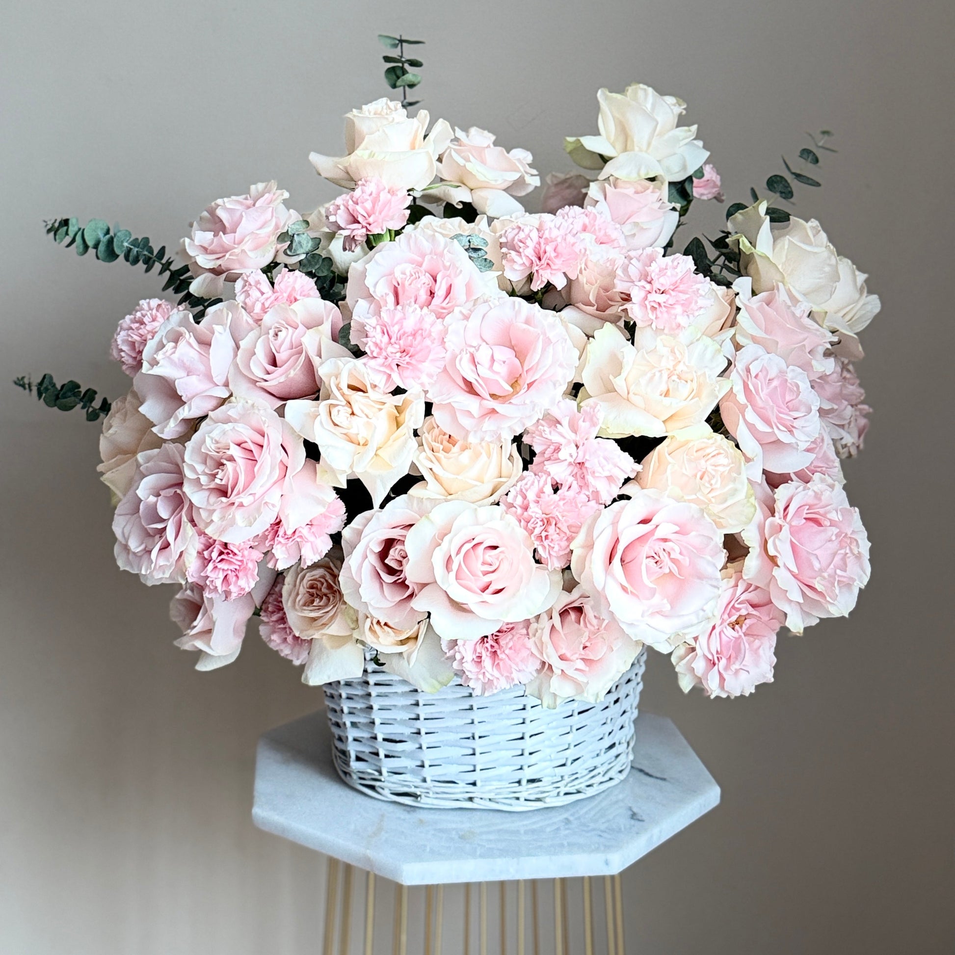 Bouquet of pink and white flowers in a white large basket