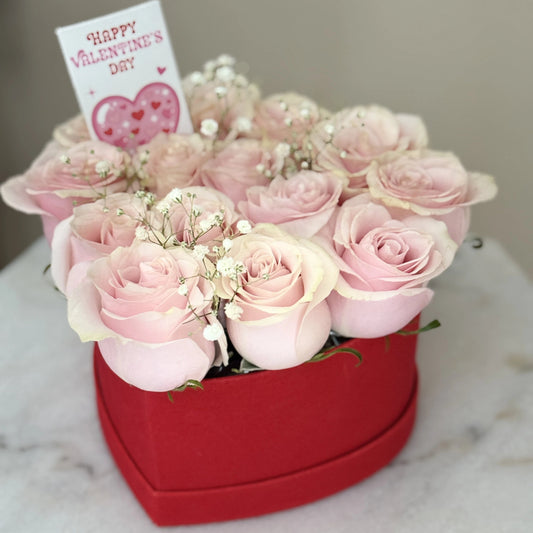 Heart-shaped box of pink roses with a Valentine's Day card.